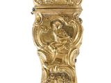 une image représentant une horloge en or sur laquelle figure un visage