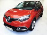 La voiture rouge est garée dans une pièce blanche au sol blanc.