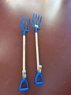 pair of blue plastic garden fork with wooden handle on brown table
