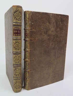 un vieux livre à la couverture brune posé sur une surface blanche