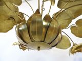 a gold chandelier with leaves hanging from it ' s ceiling