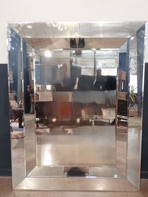un miroir au milieu d'une pièce, avec une personne à l'arrière-plan