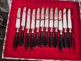 nine knives in a red box on a table