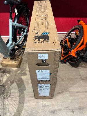 un vélo posé à côté d'un carton par terre