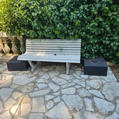 un banc en bois posé au milieu d'une allée pavée