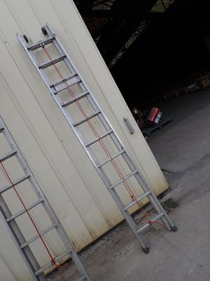 two ladders leaning against the wall of a building