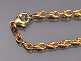 a gold chain with a heart on it on a gray surface