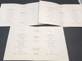 three pages of a menu on a black table