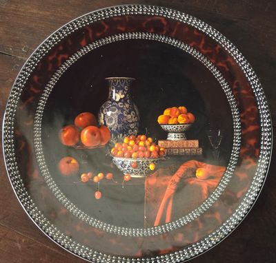 une plaque de verre sur laquelle est représentée une composition d'oranges et d'un vase