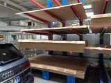 a car that is parked in front of a rack of shelves