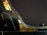 a black and gold sculpture of a cat on a black base