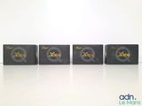 four black boxes with gold letters are lined up on a white surface