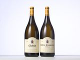 two bottles of white wine sitting on top of a table