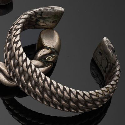 un gros plan d'un bracelet en argent orné d'un serpent