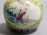 a small vase with a painting on it sitting on a table