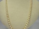 a close up of a necklace with pearls on a mannequin
