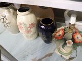 many vases that are on a shelf in the kitchen