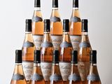 six bouteilles de vin sont alignées sur une table en bois