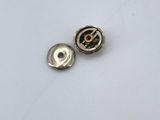two metal buttons that are on a white surface