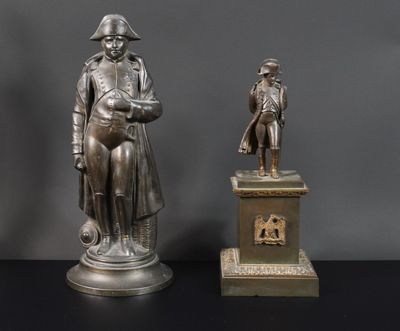 deux statues en bronze représentant un homme et une femme, posées sur un socle
