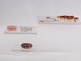 three pieces of jewelry on display in a clear display case