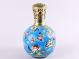 un petit vase bleu orné de fleurs, posé sur une surface blanche