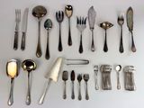 a lot of silver spoons and forks laid out on a table