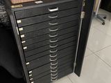 a black filing cabinet with a magazine on top of it