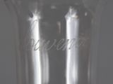 a clear glass with writing on it sitting on a table