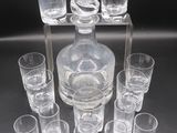 many glasses and a decanter sitting on a table