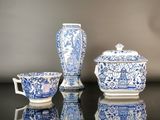 trois vases bleus et blancs et un bol posés sur une table