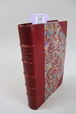un livre rouge sur lequel est collée une étiquette violette
