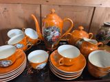 de nombreuses tasses et soucoupes posées sur un plateau, avec une théière