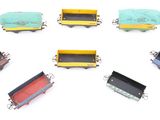 many different colors of train cars on a white surface