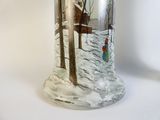 a glass vase with a picture of a house in the snow