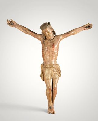 une statue en bois représentant Jésus sur la croix, sur fond blanc