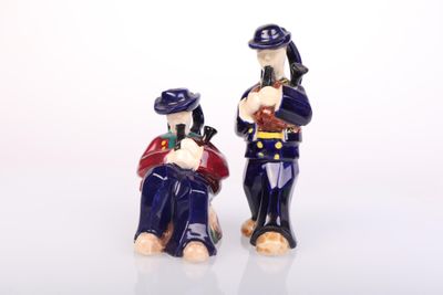 two figurines of a man and a woman sitting on a bench