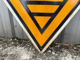 a triangular sign that is on the ground near a building