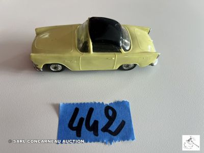 une petite voiture jaune posée à côté d'une feuille de papier bleue