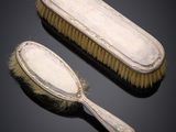a pair of silverplated brushes and a brush on a black background