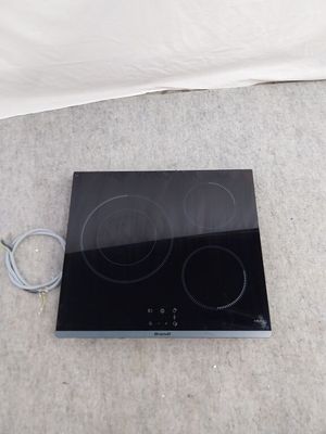 une plaque de cuisson noire posée par terre à côté d'un drap blanc