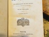 un livre ouvert posé sur une table à côté d'une pile de livres