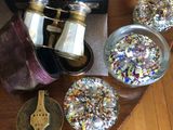 une table sur laquelle se trouvent une horloge, une paire de jumelles et d'autres objets