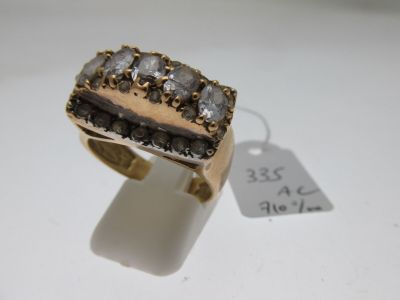 a close up of a gold ring with diamonds on a white surface