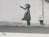 a black and white picture of a girl holding a red balloon