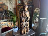 a statue of a woman holding a child in a living room
