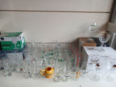 de nombreux verres et tasses posés sur la table, à côté d'une boîte de verres à vin