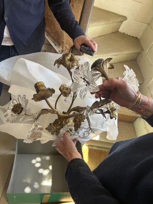 Deux personnes regardent un vase en verre contenant des fleurs.
