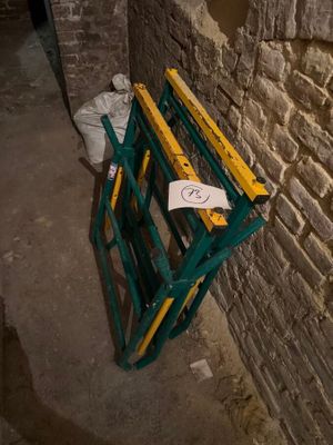 une photo d'un banc vert et jaune adossé à un mur de pierre