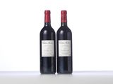 two bottles of red wine sitting on top of a table